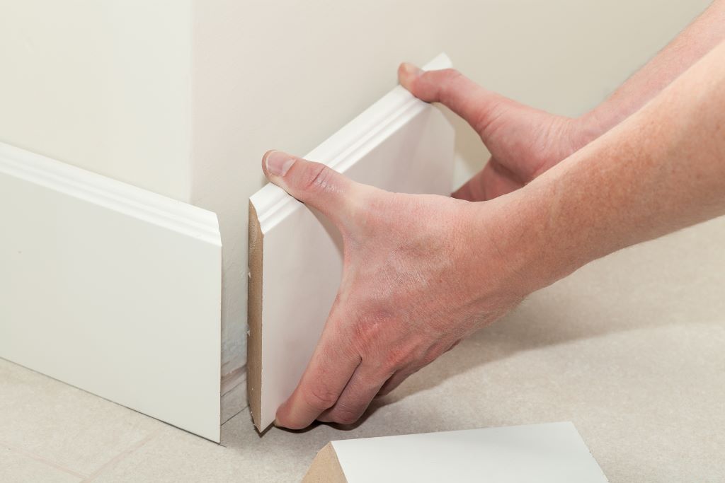 Person placing trim on the wall